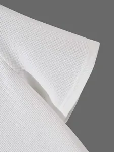 Detailansicht der hochwertigen weißen Waffelstrick-Struktur an einem Herren-Henley-T-Shirt