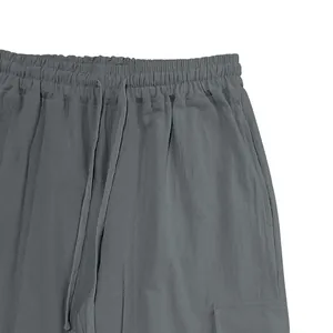 Detailed view of grey cotton linen casual trousers with drawstring waist and cargo pockets