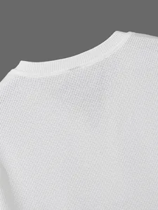 Detailansicht des weißen Waffelstrickstoffs am Ausschnitt eines klassischen Herren-Henley-Shirts