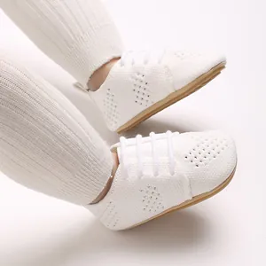 Detailed close-up of white knit baby shoes with hollow design and cotton laces