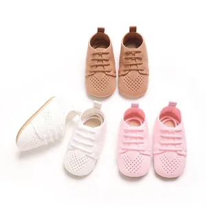 Detailed overhead shot of hollow knit baby shoes in white, pink, and brown colors.
