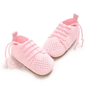 Close-up view of pink knitted baby shoes featuring a delicate hollow pattern design.