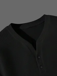 Nahaufnahme eines schwarzen Henley-Shirts für Herren aus Waffelstrick mit V-Ausschnitt