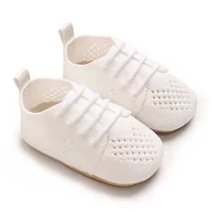 Close-up of white knitted baby shoes with breathable hollow-out mesh design