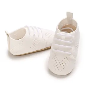Close-up of white knitted infant walking shoes with breathable hollow design