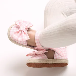 Makro-Detail von Baby-Mädchen-Sandalen mit rosa Karomuster und Schleife für den Sommer