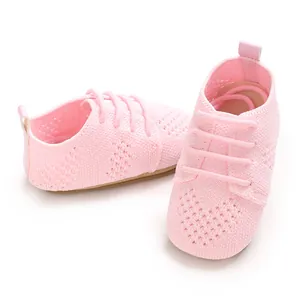 Close-up view of pink hollow knit infant flat shoes featuring decorative laces and vintage style