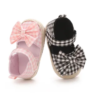 Paar Gingham-Sandaletten für Baby-Mädchen mit Schleife in Pink und Schwarz Farbe.
