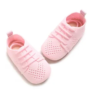 Close-up of pink knitted baby shoes with a cute heart-shaped hollow-out texture.
