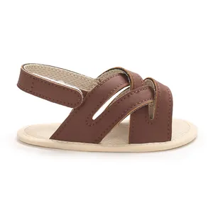 Vista detallada de sandalias de cuero PU marrón para bebé con suelas blandas y velcro.