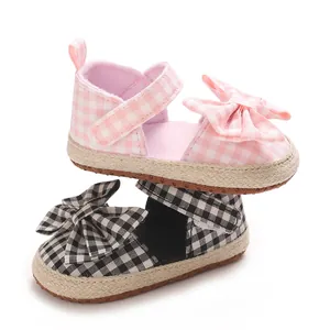 Detailansicht von Babysandalen für Mädchen mit Karomuster und Zierschleifen