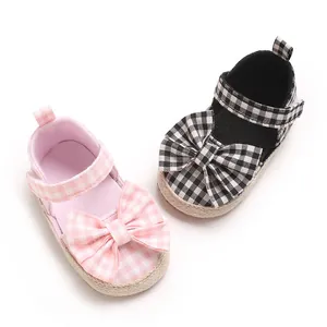 Detailansicht der rosa und schwarz karrierten Baby-Lernlaufschuhe mit süßen Schleifen