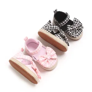 Detailansicht der Gingham-Lauflernschuhe für Babys mit großen Schleifenverzierungen.