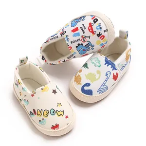 Detalle de zapatos para bebé con estampados coloridos de dinosaurios y coches de dibujos.