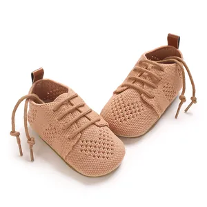 Macro view showing hollow knit texture and lace-up detail of pink baby princess shoes