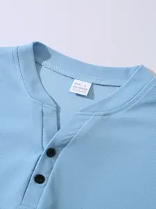 Detailansicht eines hellblauen Henley-Shirts aus Waffelstrick mit Knöpfen und Etikett