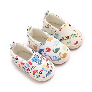 Vista detallada de zapatos para bebé de suela blanda con estampados de dinosaurios y arcoíris.