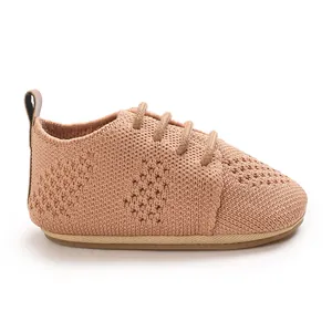 Detailed view of pink knitted baby shoes featuring a hollow design and soft flat sole
