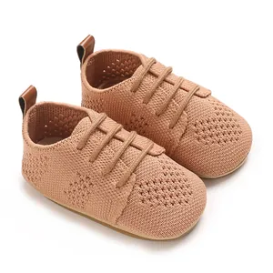 Close-up of peach knit infant flats with breathable mesh and brown leather pull tab
