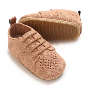 Close-up of peach knitted baby shoes with hollow-out design and soft rubber sole
