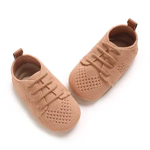 Close-up detail view of knit baby shoes with heart-shaped hollow patterns and laces.