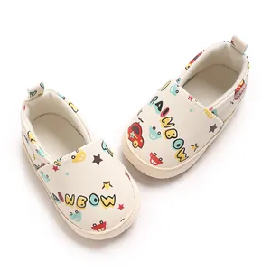 Detalle de zapatos de gateo para bebé con suela blanda y estampados de coches y arcoíris