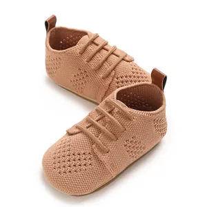 Detail view of hollow-out knitted baby shoes with decorative laces and retro style