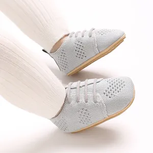 Macro view of grey hollow knit baby shoes featuring vintage design and decorative laces