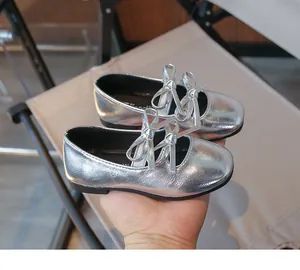 Detail view of girl's silver metallic square-toe flat shoes with elegant double bow design
