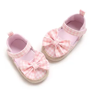 Nahaufnahme der rosa karierten Lauflernschuhe für Mädchen mit dekorativen Schleifen