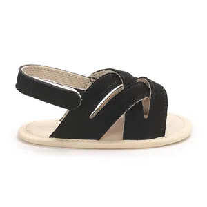 Vista lateral de sandalias para bebé en ante sintético negro con suela suave beige