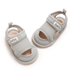 Nahaufnahme von atmungsaktiven grauen Mesh-Babysandalen mit weicher Sohle und Klett