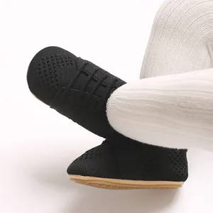 Close-up view of black hollow knit baby flat shoes with a vintage princess design