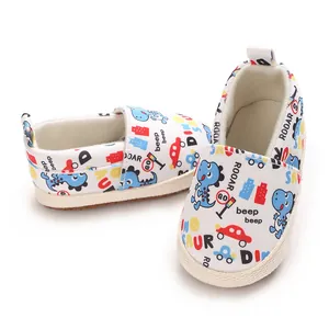 Vista detallada de zapatos para bebé con suela blanda y estampados de dinosaurios.