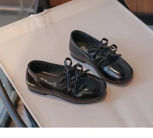 Detailed view of girls' black patent leather square toe shoes with elegant double bow ties