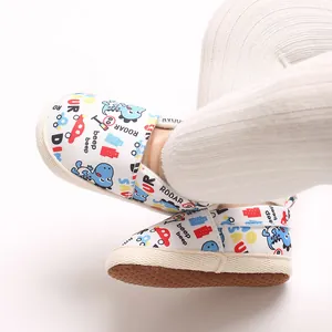 Detalle de zapatos de bebé con estampados de dinosaurios y coches de dibujos.
