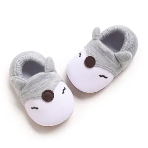Primo piano di scarpe morbide grigie e bianche per neonati con design dolce animale
