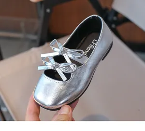 Close-up of silver girls' Mary Janes featuring a metallic finish and double bow detail