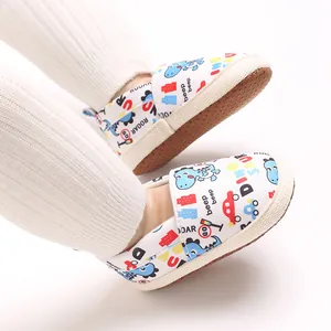 Detalle de zapatos de primeros pasos para bebé con estampado de dinosaurios y suela blanda