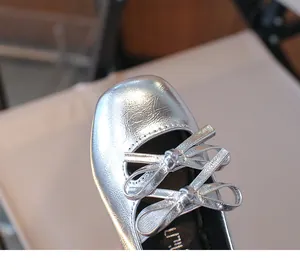 Detailed view of silver girls square toe flat shoe featuring elegant double bow design