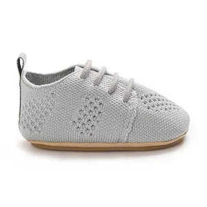 Detailed side view of light grey knitted baby flat shoe with hollow-out pattern and laces