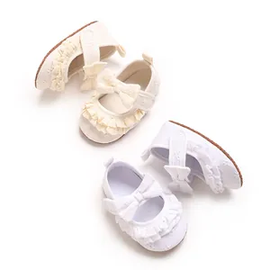 Vista dettagliata di scarpe da principessa con volant per neonata in bianco e crema