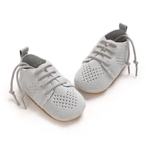 Close-up view of grey knitted infant flat shoes featuring hollow heart pattern and laces