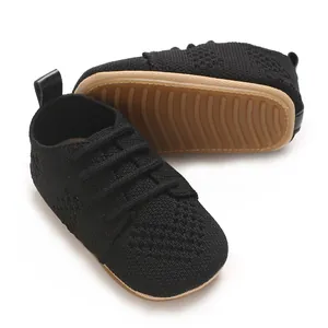 Close-up of black knit baby flat shoes with breathable hollow design and gum sole