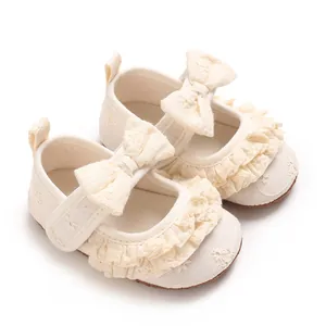 Vista dettagliata di scarpe da principessa per neonata color crema con volant e fiocco