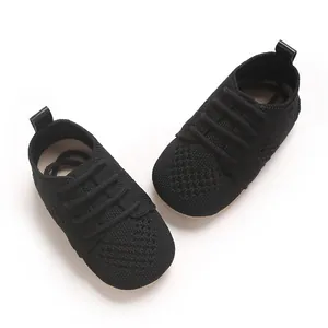 Detailed top view of breathable black knitted baby flat shoes with decorative laces.