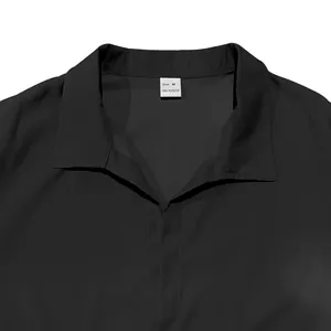 Gros plan du col d'une chemise noire pour homme montrant l'étiquette de taille M et le tissu.