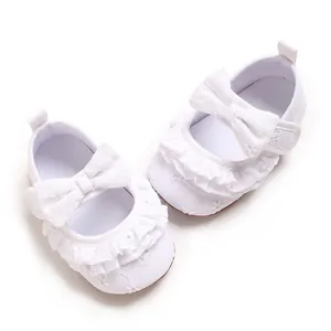 Dettaglio scarpe da principessa per neonata con balze in pizzo e fiocco decorativo