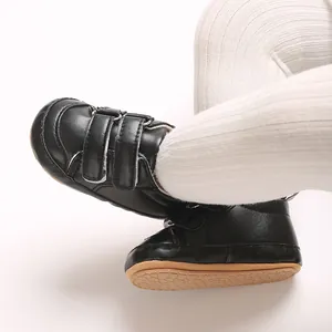 Nahaufnahme schwarzer PU-Babyschuhe mit Klettverschluss und weicher rutschfester Sohle