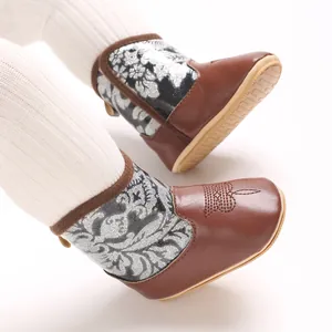Detail view of brown baby winter boots with floral glitter pattern and soft sole